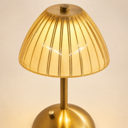 Close-up of the Livia ribbed amber shade, brushed-gold stem and domed base control