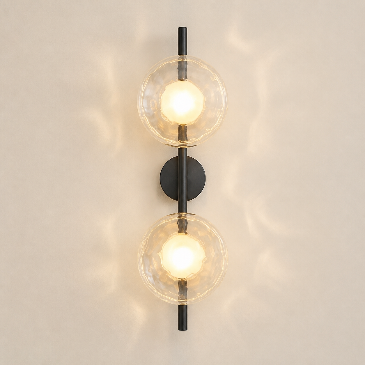 Moreton two-light wireless wall sconce in the satin-black finish with clear textured glass discs
