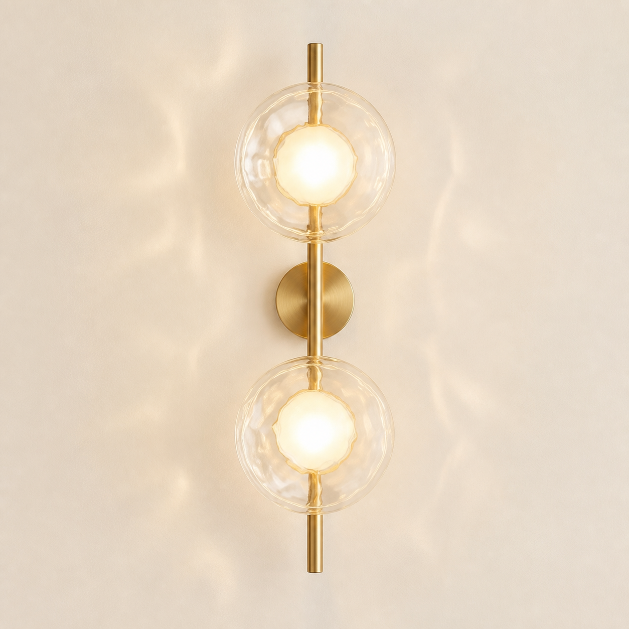 Moreton two-light wireless wall sconce in the brushed-gold finish with clear textured glass discs