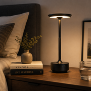 Black Pembroke cordless table lamp glowing on a bedside table in a UK bedroom