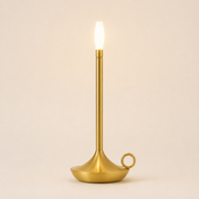 Rowan cordless table lamp in the brushed-gold finish with flame-shaped diffuser and looped base