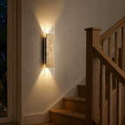 Winchester travertine wall light casting warm up-and-down light on an oak staircase landing
