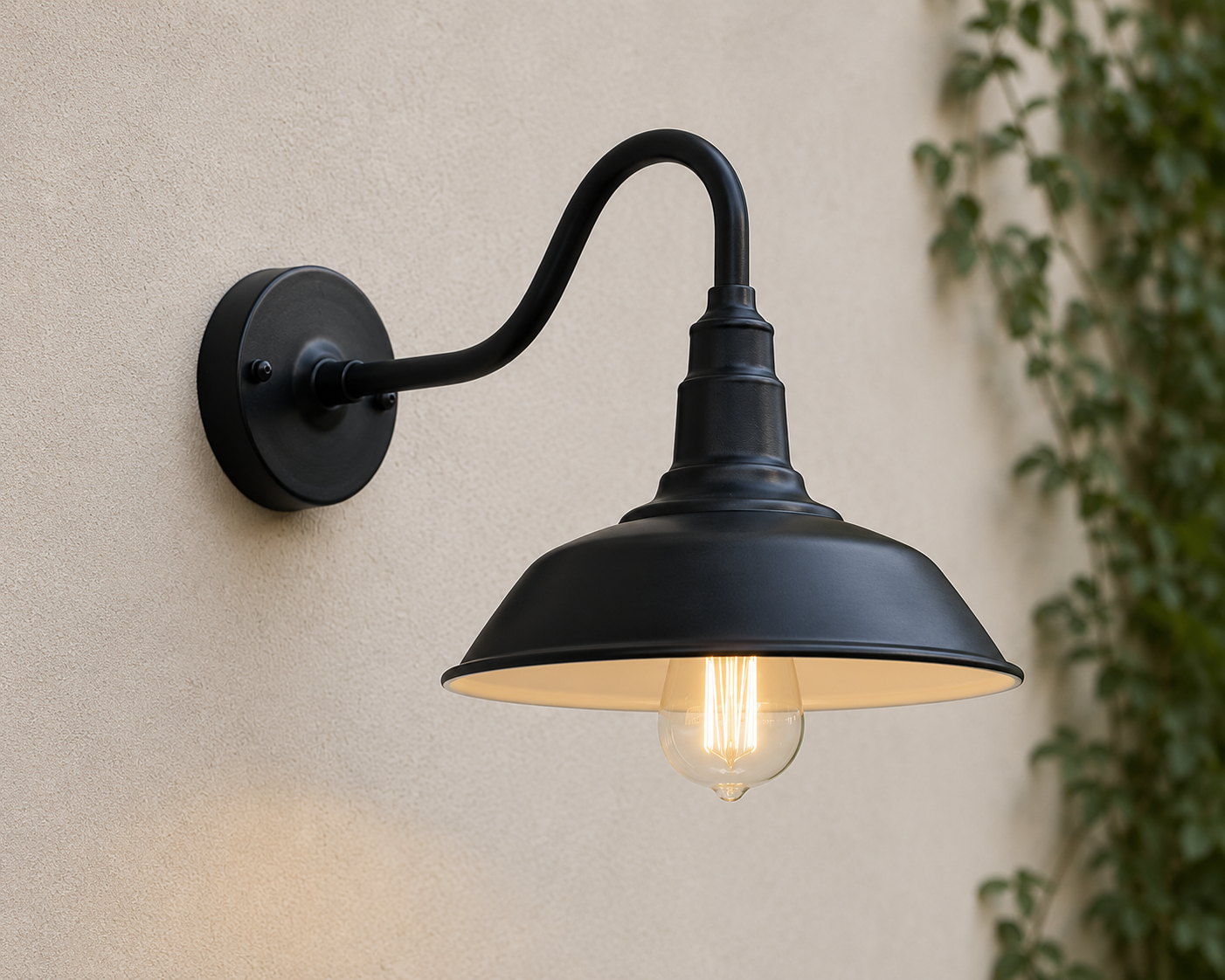 Wren gooseneck outdoor wall light in black with barn-style shade, lit on a rendered wall